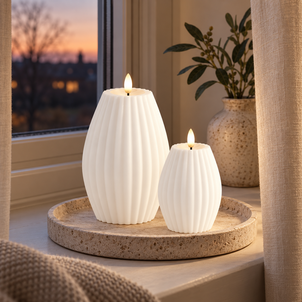 To hvide LED rillelys på stenbakke i vindueskarm med vase, gardiner og aftenhimmel udenfor