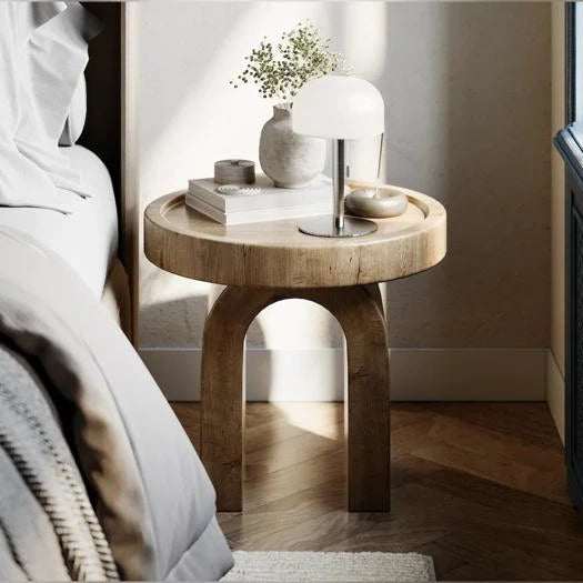 Grå LED bordlampe med hvid skærm på rundt sengebord i træ ved siden af vase og bøger