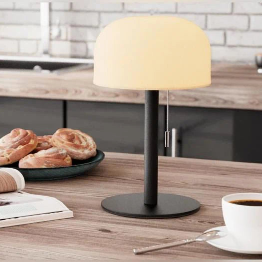 Tændt LED bordlampe med varmt hyggelys på køkkenbord med kaffe og kanelsnegle
